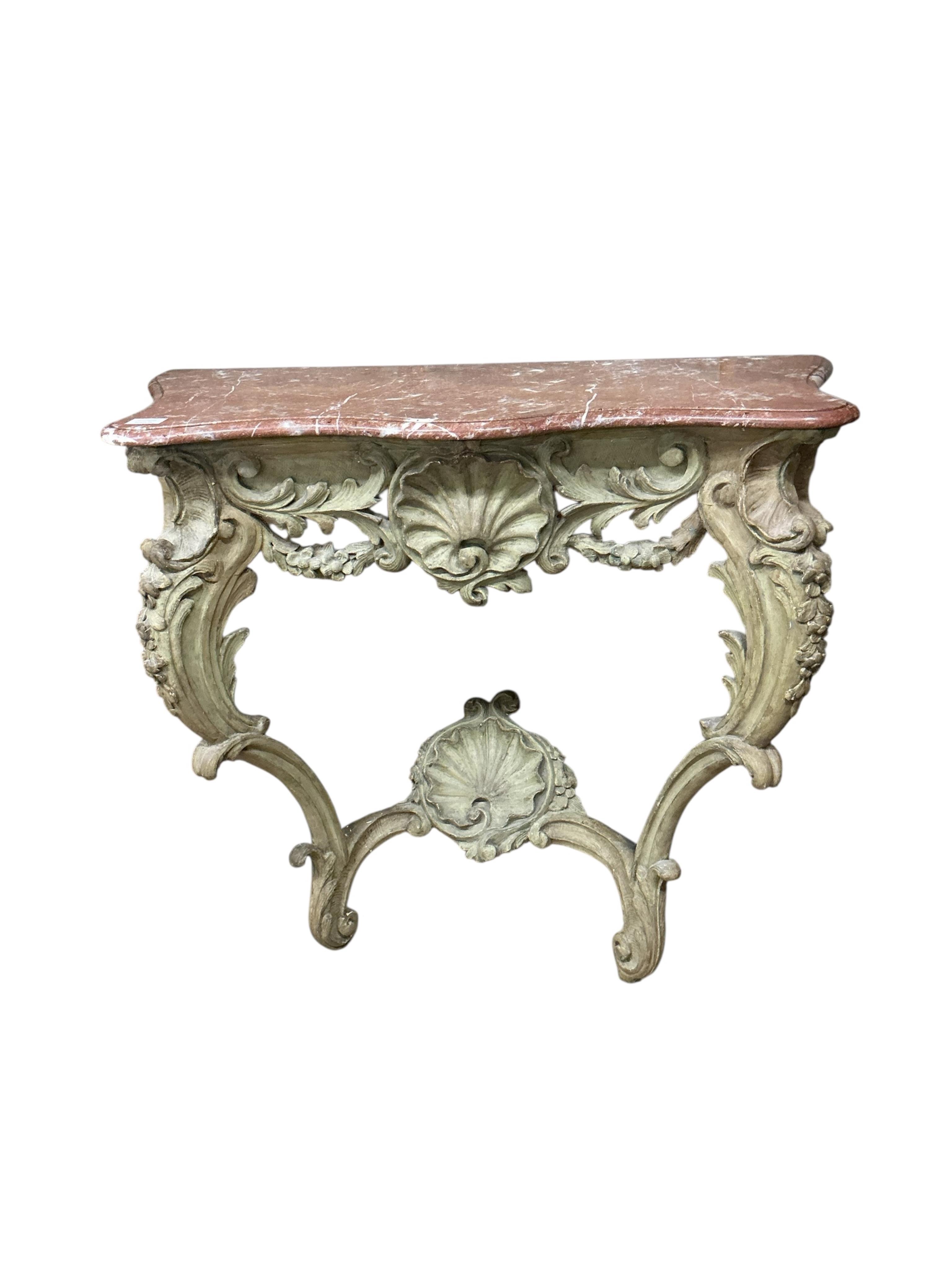 A Louis XV style console table the rouge marble serpentine top raised on a foliate, shell and floral swagged base with two cabriole style supports, width 100cm, depth 45cm, height 90cm
